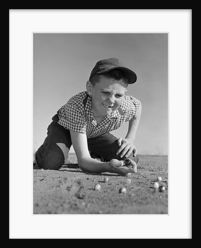 1950s 1960s Boy Playing Marbles Kneeling In The Dirt Squinting Missing A Front Tooth by Anonymous