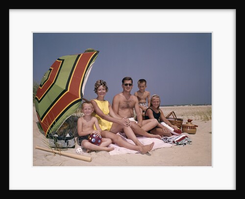 1960s Family On Sunny Beach Under Umbrella With Picnic Basket by Anonymous