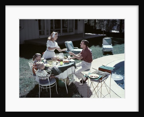 1950s Family In Backyard Having Picnic From Grill Near Swimming Pool by Anonymous