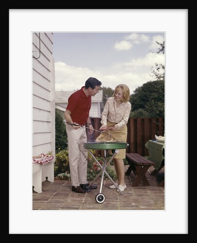 1960s Couple Man Woman Grilling Steak On Backyard Patio Bar-B-Cue Charcoal Grill by Anonymous