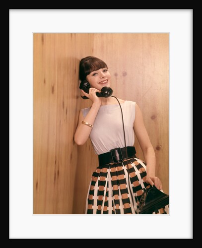 1950s 1960s Brunette Woman Talking Telephone Leaning Against Wood Panel Wall by Anonymous