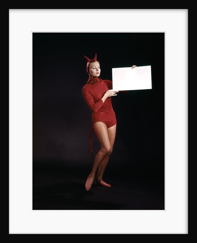 1960s Young Woman In Red Devil Costume Holding Sign Board In Hands by Anonymous