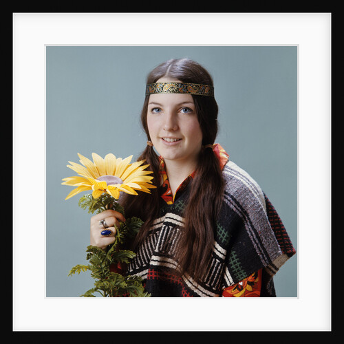 1960s 1970s Teenage Girl With Pigtails Wearing Headband And Serape Holding Sunflower by Anonymous