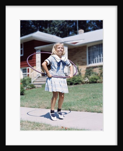 1950s 1960s Young Girl Playing With Hula Hoop Outside On Suburban Sidewalk In Sailor Style Dress by Anonymous