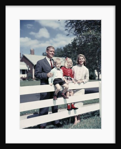 1950s 1960s Family Portrait Mother Father Daughter Son At White Fence Of Suburban Home by Anonymous