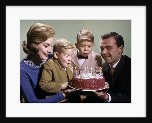 1960s Mother And Father Holding Birthday Cake And Sons Blowing Out Candles by Anonymous
