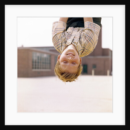 Red Haired Boy Hanging Upside Down In Elementary School Yard by Anonymous