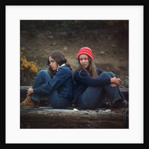 1970s Two Sad Serious Teenage Girls Sitting Back To Back Outside by Anonymous