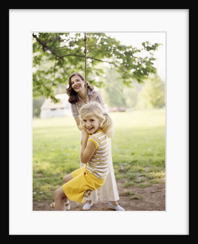 1970s Woman Mother With Girl Daughter Swinging Playing On Rope Swing by Anonymous