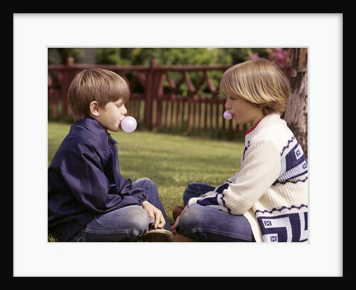 1970s Girls Sit Face To Face Blowing Pink Bubbles With Bubble Gum by Anonymous