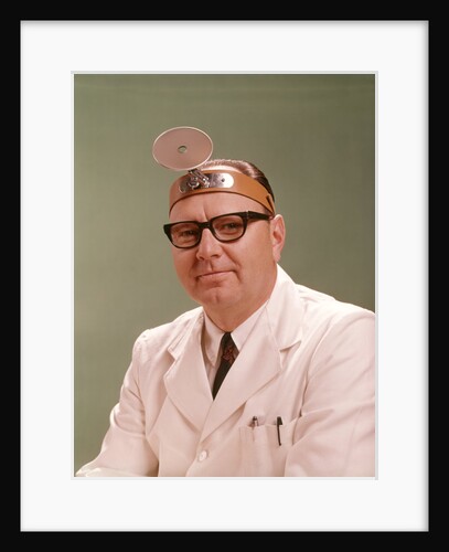 1950s 1960s Doctor Wearing Diagnostic Head Mirror On Forehead by Anonymous