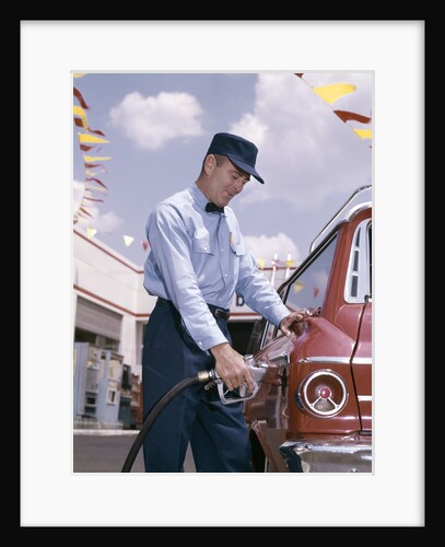 1950s 1960s Service Station Attendant With Gasoline Pump Hose Filling Gas Tank Of Automobile by Anonymous