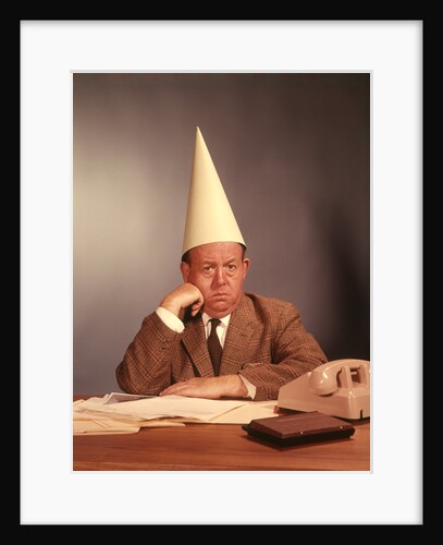1960s Sad Depressed Businessman Wearing Dunce Cap by Anonymous