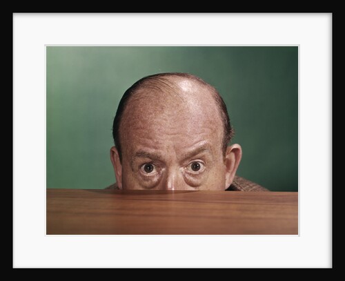 1960s Balding Man Peeking Over Desktop With Only Top Half Of Head Showing by Anonymous