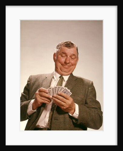 1960s Satisfied Man Looking At Hand Of Playing Cards by Anonymous