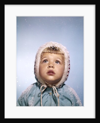 1960s Cold Little Girl In Winter Coat And Hood Looking Up At Falling Snow by Anonymous