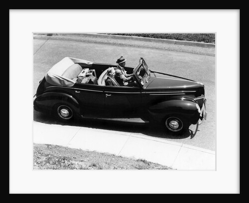 1930s 1940s Couple Driving 1938 Convertible Four Door Sedan Automobile With Luggage In Back Seat by Anonymous