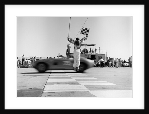 1960s Man Jumping Waving Checkered Flag As Winning Sports Car Crossing The Finish Line by Anonymous