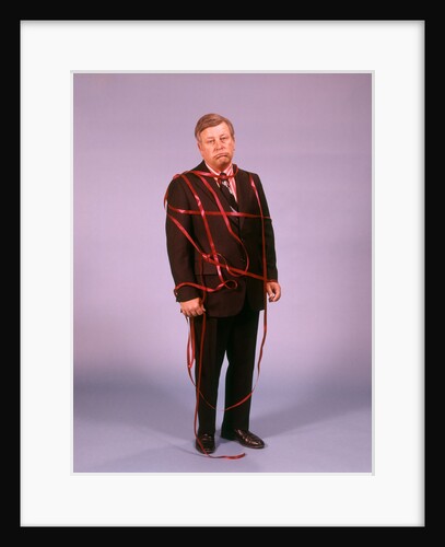 1970s Middle Aged Man Business Suit Disapointed Depressed Unhappy Tied Up In Red Tape by Anonymous