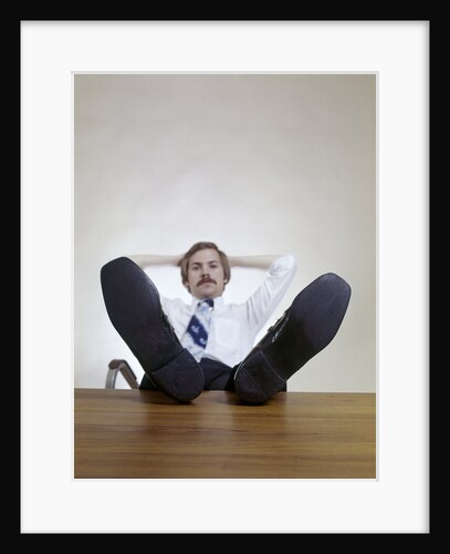 1970s Man Sitting With Feet Up On Office Desk Relaxing by Anonymous