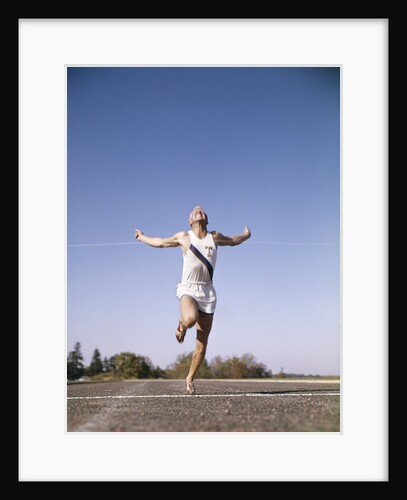 1960s Man Winning Race Running Through Tape At Finish Line by Anonymous
