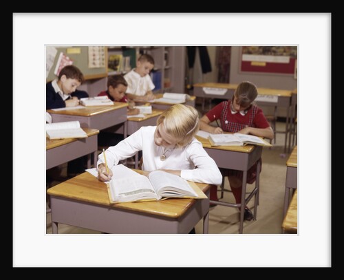 1960s Elementary School Children In Classroom At Desks Working With Books And Papers Boy Girl by Anonymous