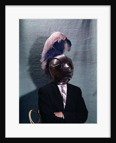 1960s Businessman Wearing 16th Century Medieval Helmet With Visor Closed Blue White Feather by Anonymous
