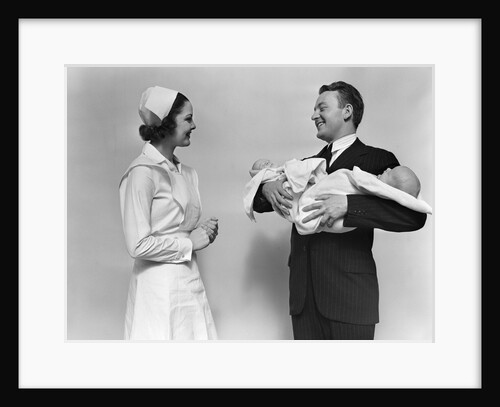 1930s 1940s Woman Nurse Talking With Man Proud New Father Holding Newborn Twin Babies by Anonymous