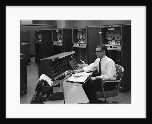 1960s Man In Shirt Tie and Thick Black Glasses Working With IBM Data Processing System by Anonymous