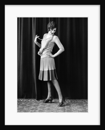 1920s Flapper Woman Posing Hand On Hip Holding String Of Pearls Stretching Leg Checking Hosiery Seams by Anonymous