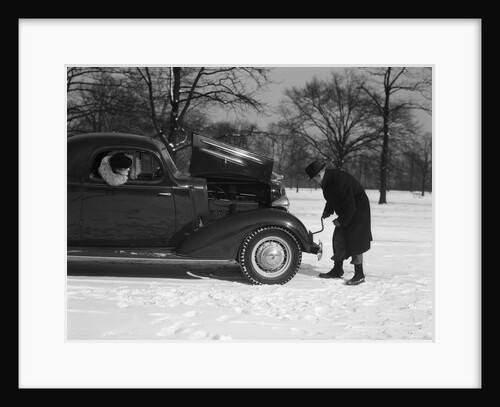 Woman Passenger Watching Man Motorist Try To Crank Start A Chevrolet Coupe Stalled In Snow by Anonymous