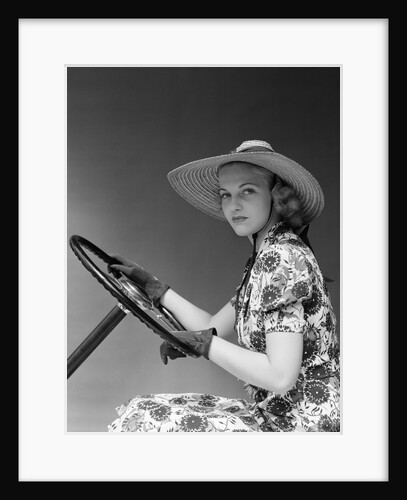 1930s 1940s Woman Wearing Straw Hat Sun Dress Driving Gloves Holding Auto Mobile Steering Wheel Looking At Camera by Anonymous