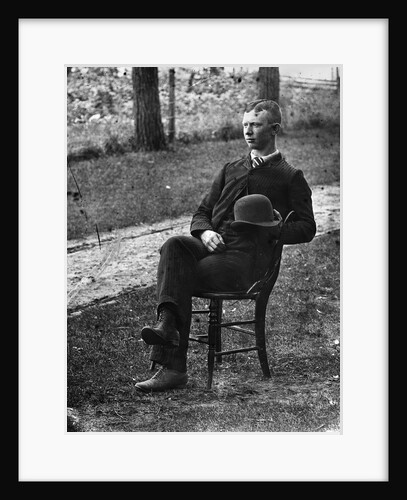 1890s 1900s Side View Of Man Wearing Suit Seated On Chair Outside Holding Bowler Hat by Anonymous