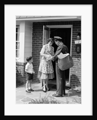 1950s Suburban Mom At Home Front Door With Son Watching Receiving Package From Mailman by Anonymous