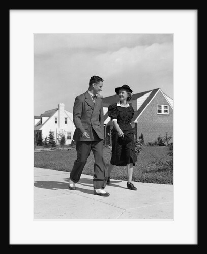 1940s Teenage Couple Walking On Suburban Sidewalk by Anonymous