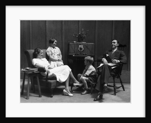 1930s Family Of Four In Living Room Gathered Around Listening To Radio by Anonymous