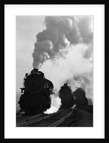 1930s 1940s Head-On View Of Three Steam Engines Silhouetted Against Billowing Smoke And Steam Outdoor by Anonymous