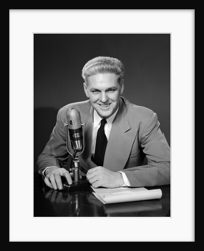 1950s Man Radio Announcer Newscaster Sitting Speaking At Microphone Studio Indoor by Anonymous