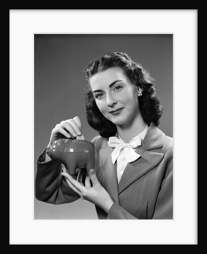 1940s Woman Putting Change Into Piggy Bank by Anonymous
