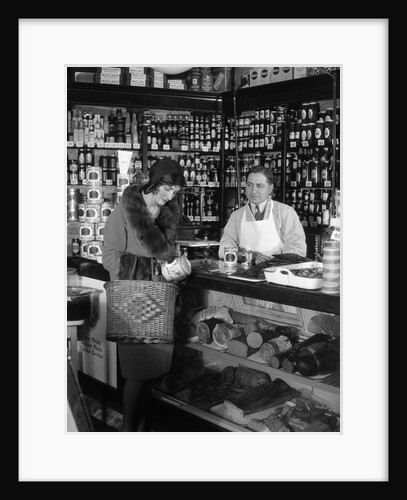 1920s Store Clerk Watching Woman Grocery Shopping Reading Label On Canned Goods by Anonymous