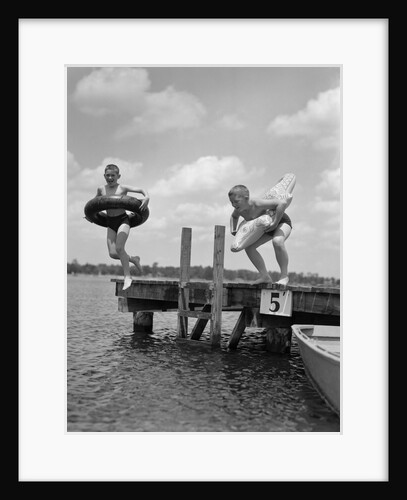 1940s 1950s Two Boys Wearing Inflatable Inner Tubes About To Jump In Lake Off Pier by Anonymous