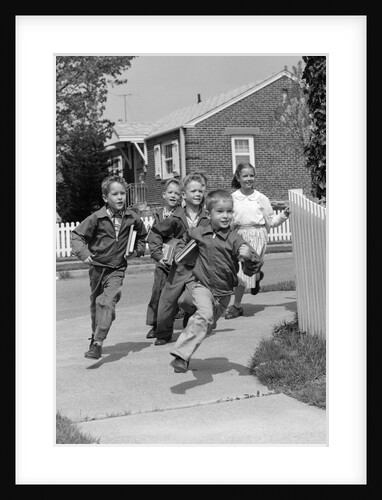 1950s School Children Running Around Corner Of Picket Fence In Suburban Neighborhood by Anonymous