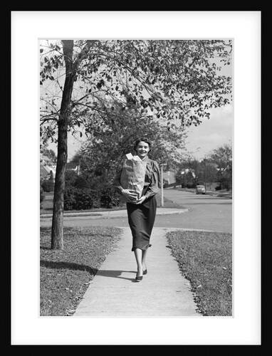 1950s Woman Walking On Sidewalk Carrying A Grocery Bag Full Of Food by Anonymous