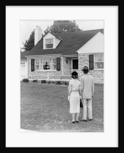 1940s 1950s Couple Standing Outside Looking At Stone Suburban House by Anonymous