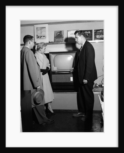1950s Couple With Salesman In Electric Appliance Store Shopping For Television by Anonymous