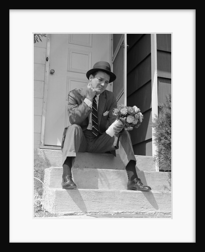 1950s Man In Suit And Hat Holding Flowers Sitting Outside Front Door On Steps Looking Sad by Anonymous