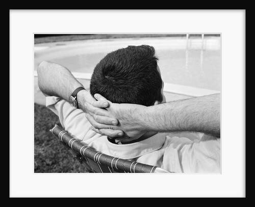 1970s Man With Hands Folded Behind Head Stretched Out In Lounge Chair Poolside by Anonymous