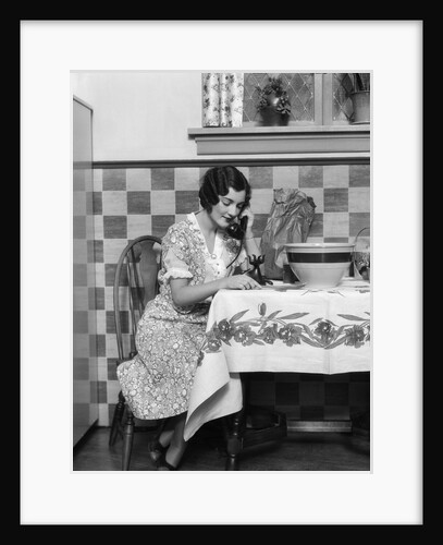 1920s Woman Sitting At Kitchen Table With Table Cloth While On Phone by Anonymous
