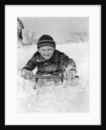 1940s Boy On Sled In Snow Facing Camera Hands And Jacket Covered In Snow by Anonymous