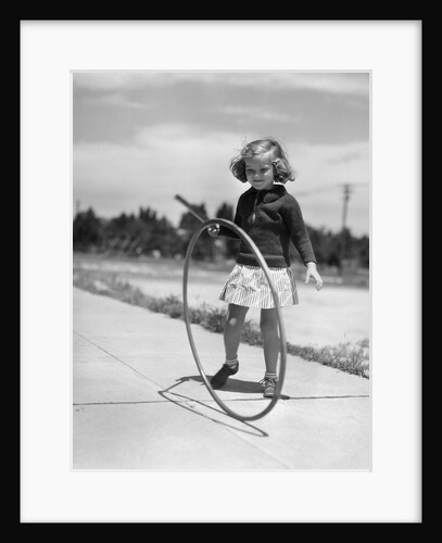 1930s Girl Playing With Hoop And Stick On Sidewalk by Anonymous